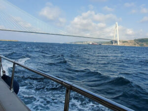 view from a passenger boat of a tanker going under the bosphorus bridge