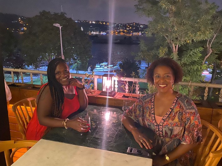 two women smiling during an outdoor restaurant dinner