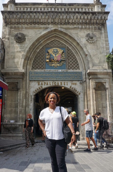 Woman standing at contrete archway entrance to Istanbul Grand Bazar