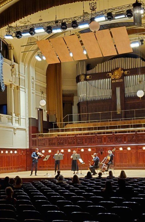 Five string instrument performers on stage at Prague's Smetana Hall