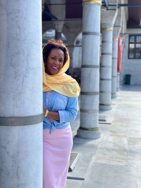 Woman with yellow scarf standing at entrance to Rüstem Paşa Mosque